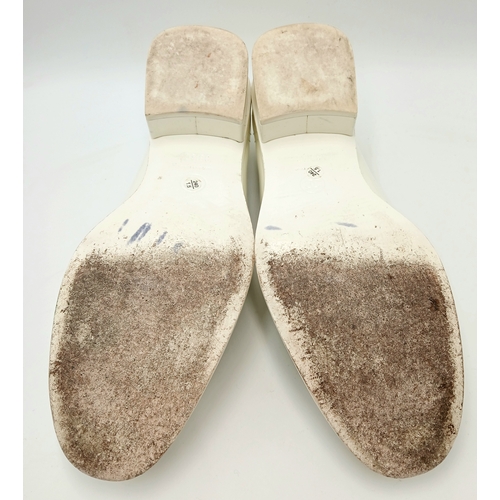 594 - A pair of Chanel White Patent Leather Chain Loafers. Gold-tone CC charm and chain detail across the ... 