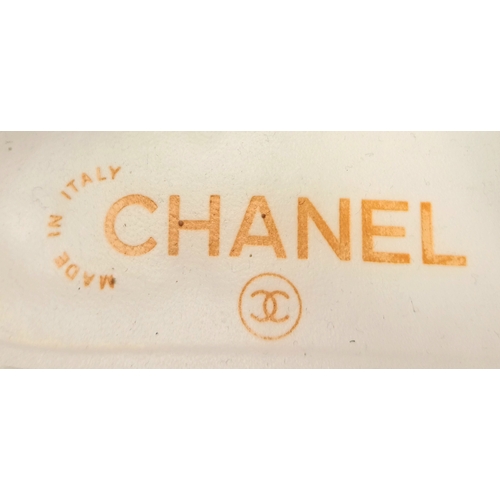 594 - A pair of Chanel White Patent Leather Chain Loafers. Gold-tone CC charm and chain detail across the ... 