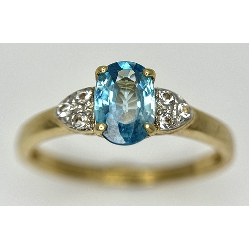 643 - A 9K Yellow Gold Blue Zircon and White Topaz Ring. 0.957ct Cambodian oval cut centre stone with 0.06... 