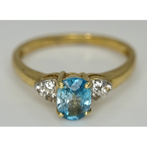 643 - A 9K Yellow Gold Blue Zircon and White Topaz Ring. 0.957ct Cambodian oval cut centre stone with 0.06... 
