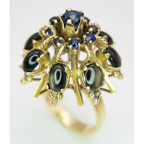 553 - A 14K Yellow Gold Sapphire Burst Ring. Eight black star oval sapphires in surround form of eight sma... 