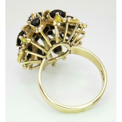 553 - A 14K Yellow Gold Sapphire Burst Ring. Eight black star oval sapphires in surround form of eight sma... 
