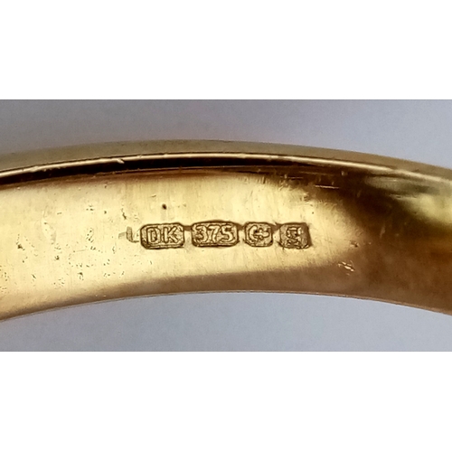 574 - A 9K Yellow Gold Blue Topaz Ring. Size N, 8.4g total weight.