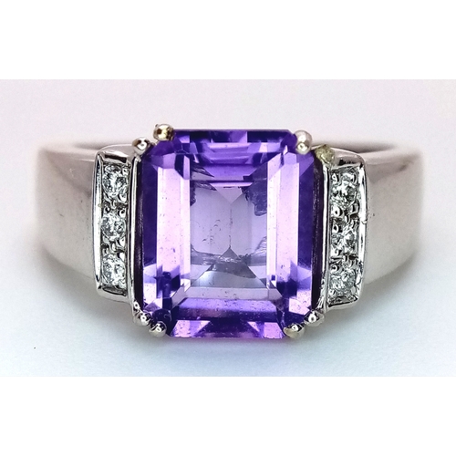 615 - An 18K White Gold (tested) Amethyst and Diamond Ring. A 2.5ct step cut amethyst with a three round b... 