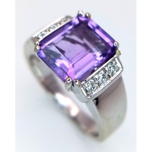 615 - An 18K White Gold (tested) Amethyst and Diamond Ring. A 2.5ct step cut amethyst with a three round b... 