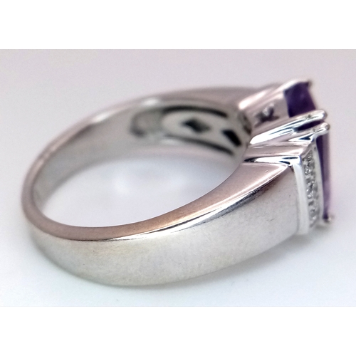 615 - An 18K White Gold (tested) Amethyst and Diamond Ring. A 2.5ct step cut amethyst with a three round b... 