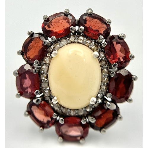 831 - An Opal, Garnet and Diamond Ring. Central 2ct opal cabochon with garnet and diamond surround. Set in... 