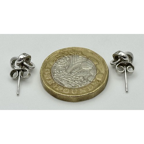 873 - A Pair of 9K White Gold Diamond Knot Stud Earrings. 1.95g.