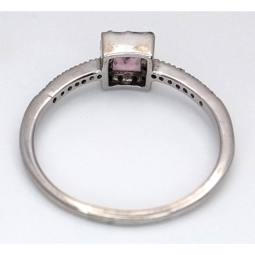 757 - An 18K White Gold, Diamond and Pink Sapphire Ring. Princess cut sapphire with baguette diamond surro... 