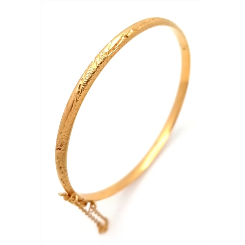 103 - An 18k yellow gold engraved bangle, 8g total weight, 6cm bangle diameter. Ref: 1624I.