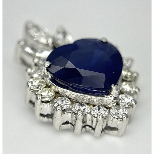 107 - An 18K White Gold, Sapphire and Diamond Pendant. A c. 2ct Madagascan heart-shaped blue sapphire with... 