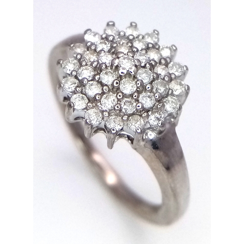 125 - A 9K WHITE GOLD DIAMOND SET CLUSTER RING. 0.25CTW. 3.9G. SIZE O. SC4034.