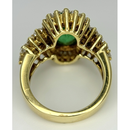 79 - An 18K Yellow Gold Emerald and Diamond Ring. A 2ct central oval cut Brazilian emerald is surrounded ... 