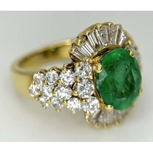 79 - An 18K Yellow Gold Emerald and Diamond Ring. A 2ct central oval cut Brazilian emerald is surrounded ... 