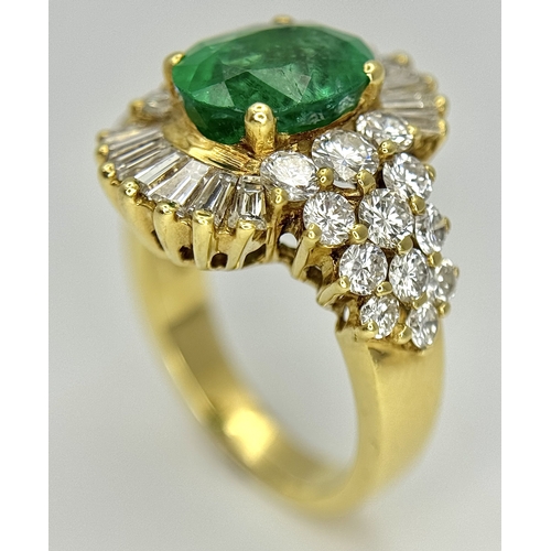 79 - An 18K Yellow Gold Emerald and Diamond Ring. A 2ct central oval cut Brazilian emerald is surrounded ... 