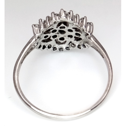 61 - AN 18K WHITE GOLD DIAMOND CLUSTER RING. 0.20CTW. 3.4G. SIZE N. REF-9808.