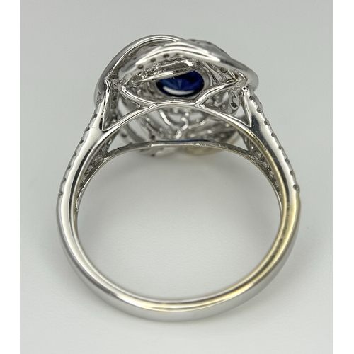 72 - An 18K White Gold, Diamond and Sapphire Swirl Ring. A 0.75ct round cut sapphire is the eye in a diam... 