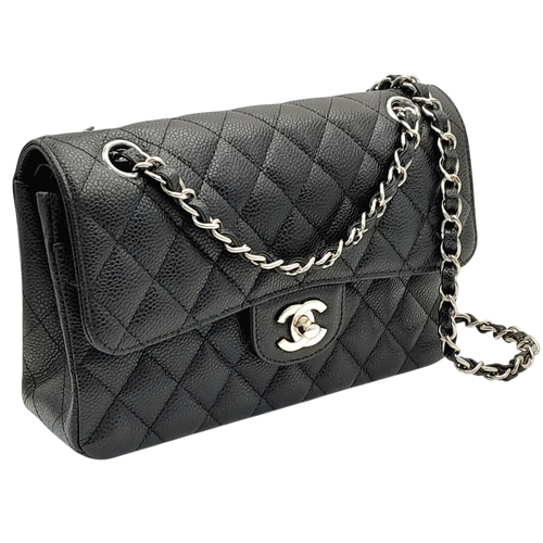 A Chanel Black Caviar Classic Double Flap Bag. Black caviar leather exterior with silver-tone hardware, chain shoulder strap and CC turn-lock closure. Burgundy leather interior with one main compartment and two opened pockets. Few tiny stains exterior, but overall in very good condition. Approx 23cm length x 15cm height x 6cm depth. Comes with a dust cover. Please see photos or request a condition report. Ref: JJ208.