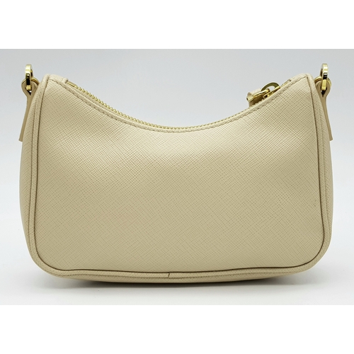 104 - A Prada Mini Re-Edition Saffiano Cream Leather Handbag. Gold-tone hardware. Comes with a certificate... 