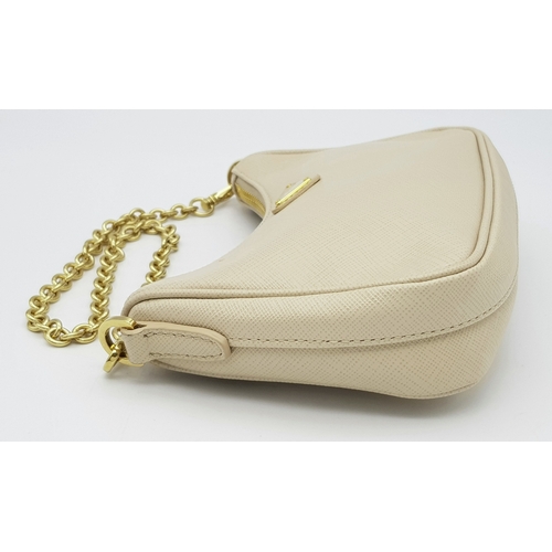 104 - A Prada Mini Re-Edition Saffiano Cream Leather Handbag. Gold-tone hardware. Comes with a certificate... 