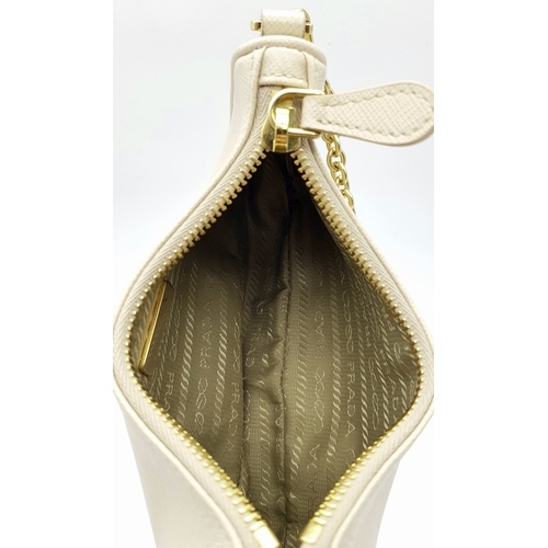 104 - A Prada Mini Re-Edition Saffiano Cream Leather Handbag. Gold-tone hardware. Comes with a certificate... 