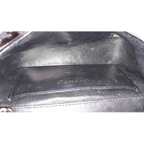 69 - A Chanel Camellia Flap Bag in Black Patent Leather. Exterior open pocket. Gold tone hardware. Classi... 