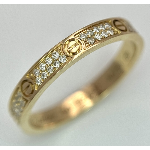29 - An 18K Gold and Diamond Pave Cartier Love Band Ring. 4mm width. Size 50. 2.1g. Comes with a Cartier ... 