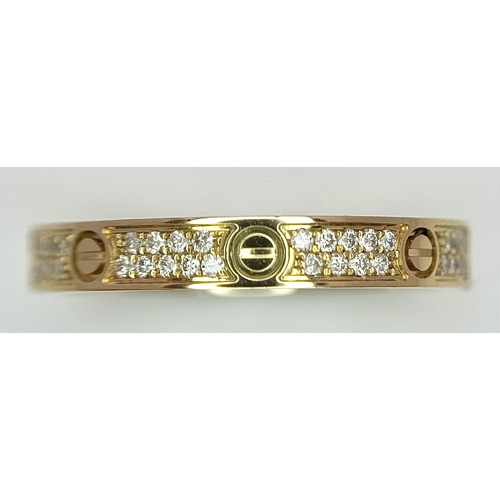 29 - An 18K Gold and Diamond Pave Cartier Love Band Ring. 4mm width. Size 50. 2.1g. Comes with a Cartier ... 