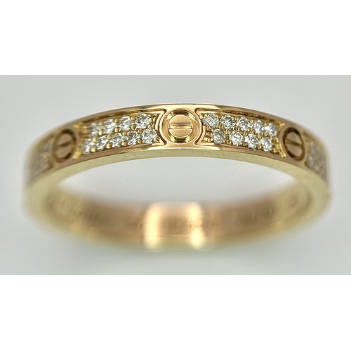 29 - An 18K Gold and Diamond Pave Cartier Love Band Ring. 4mm width. Size 50. 2.1g. Comes with a Cartier ... 