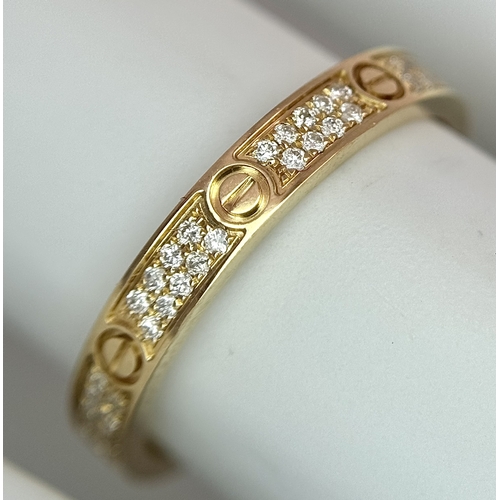 29 - An 18K Gold and Diamond Pave Cartier Love Band Ring. 4mm width. Size 50. 2.1g. Comes with a Cartier ... 