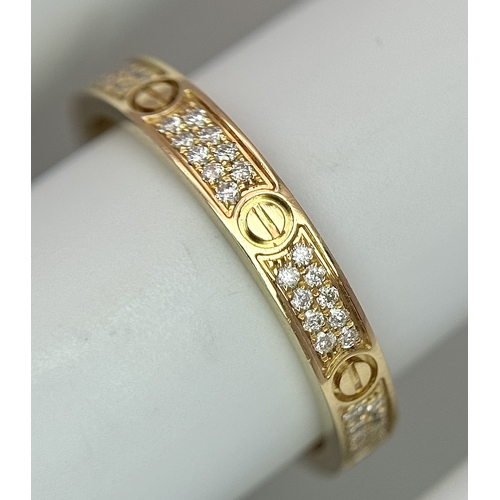 29 - An 18K Gold and Diamond Pave Cartier Love Band Ring. 4mm width. Size 50. 2.1g. Comes with a Cartier ... 