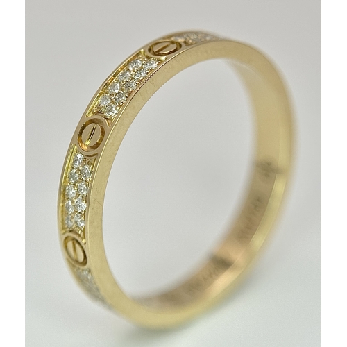 29 - An 18K Gold and Diamond Pave Cartier Love Band Ring. 4mm width. Size 50. 2.1g. Comes with a Cartier ... 