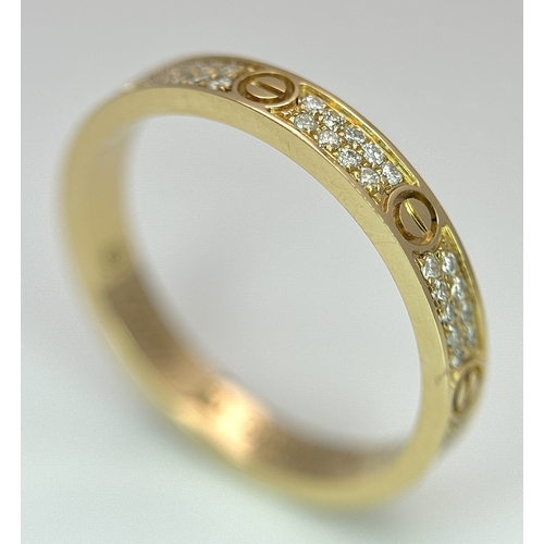29 - An 18K Gold and Diamond Pave Cartier Love Band Ring. 4mm width. Size 50. 2.1g. Comes with a Cartier ... 