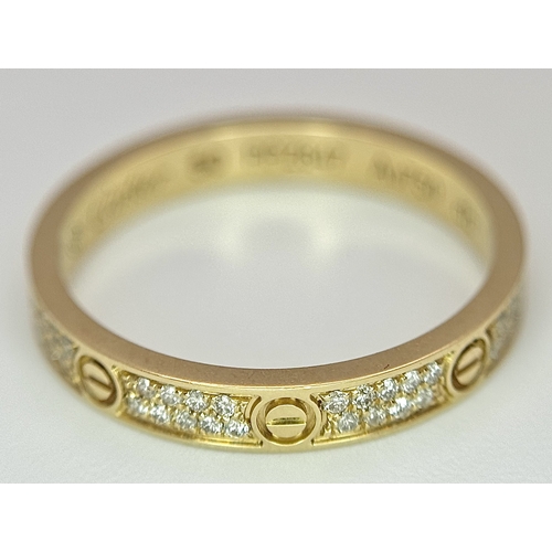 29 - An 18K Gold and Diamond Pave Cartier Love Band Ring. 4mm width. Size 50. 2.1g. Comes with a Cartier ... 