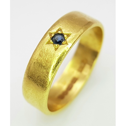 50 - A 22K Yellow Gold Band Ring with Sapphire Star Set Gemstone. 6mm width. Size J. 4.3g.