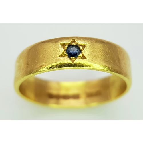 50 - A 22K Yellow Gold Band Ring with Sapphire Star Set Gemstone. 6mm width. Size J. 4.3g.
