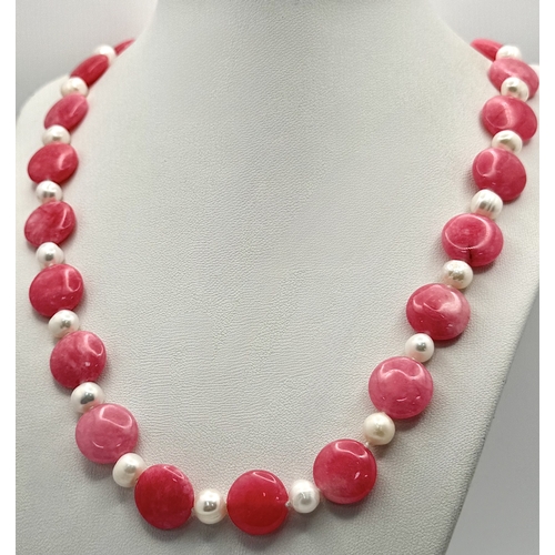 646 - A Pink Rhodochrosite and Pearl Necklace. Pink coins of rhodochrosite with white freshwater pearl spa... 