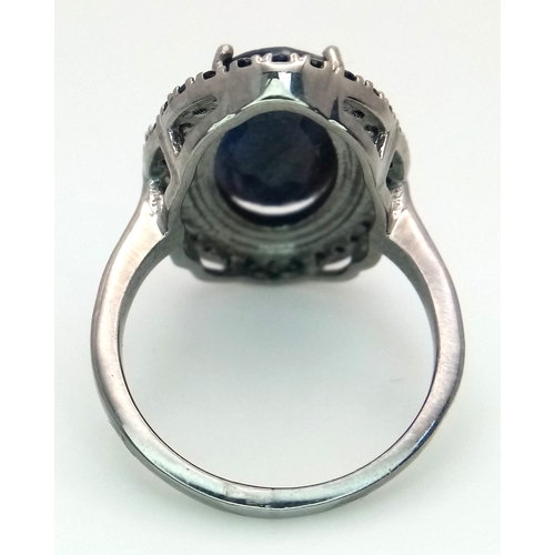 527 - A 5ct Blue Sapphire Ring with a halo of Blue Sapphire Accents. Set in 925 Silver. Size M 1/2. With c... 