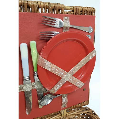 780 - A vintage wicker picnic basket with buckle fasteners, containing two original Thermos flasks, and fo... 