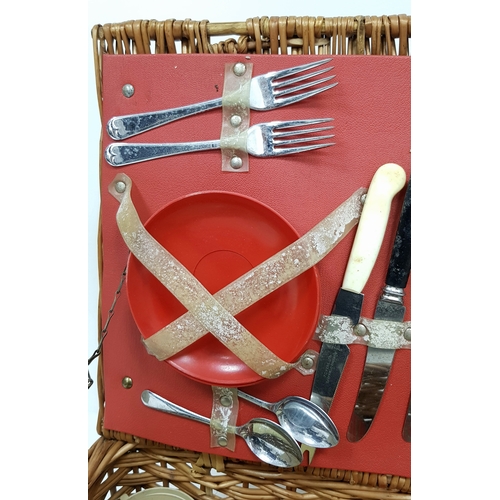 780 - A vintage wicker picnic basket with buckle fasteners, containing two original Thermos flasks, and fo... 