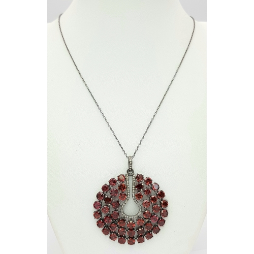 572 - A Garnet Gemstone Large Circular Pendant. Set in 925 Silver. 
5.5cm diameter. Comes with a silver ch... 