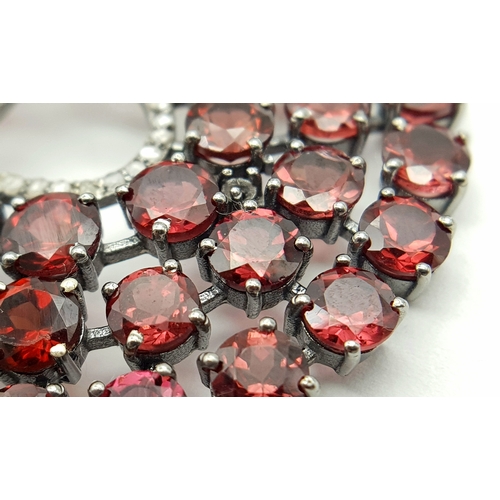 572 - A Garnet Gemstone Large Circular Pendant. Set in 925 Silver. 
5.5cm diameter. Comes with a silver ch... 