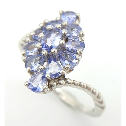 1683 - A Pretty Art Deco Style Sterling Silver Tanzanite Set Crossover Ring Size P. The Ring is set with Ov... 