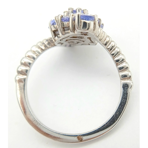 1683 - A Pretty Art Deco Style Sterling Silver Tanzanite Set Crossover Ring Size P. The Ring is set with Ov... 