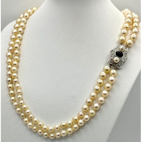 33 - A DOUBLE ROW PEARL NECKLACE WITH A PLATINUM CLASP SET WITH DIAMONDS, PEARLS AND CABACHON SAPPHIRE . ... 
