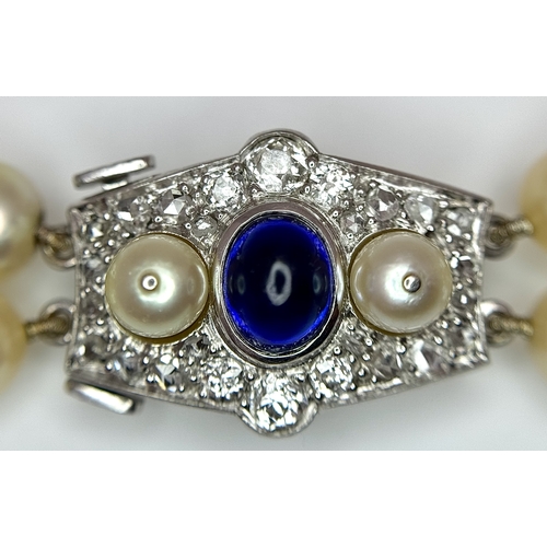 33 - A DOUBLE ROW PEARL NECKLACE WITH A PLATINUM CLASP SET WITH DIAMONDS, PEARLS AND CABACHON SAPPHIRE . ... 