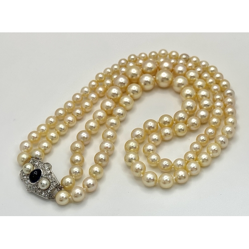 33 - A DOUBLE ROW PEARL NECKLACE WITH A PLATINUM CLASP SET WITH DIAMONDS, PEARLS AND CABACHON SAPPHIRE . ... 