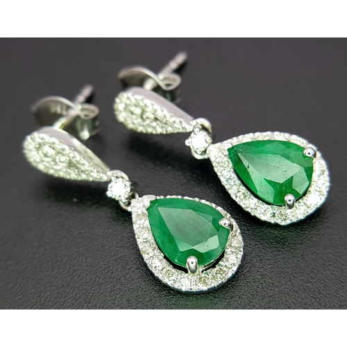 1410 - A Pair of 18K White Gold, Colombian Emerald and Diamond Drop Earrings. Each having a 1ct emerald wit... 