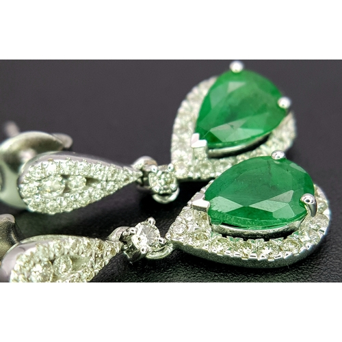 1410 - A Pair of 18K White Gold, Colombian Emerald and Diamond Drop Earrings. Each having a 1ct emerald wit... 