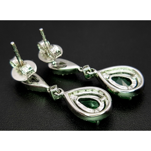1410 - A Pair of 18K White Gold, Colombian Emerald and Diamond Drop Earrings. Each having a 1ct emerald wit... 